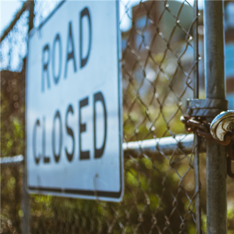 road close sign on fence